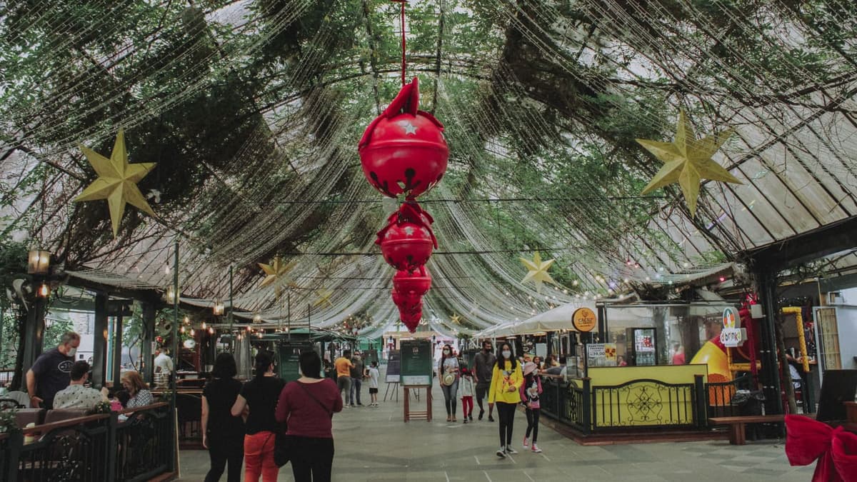 Rua de comércio popular decorada para o Natal, com enfeites suspensos