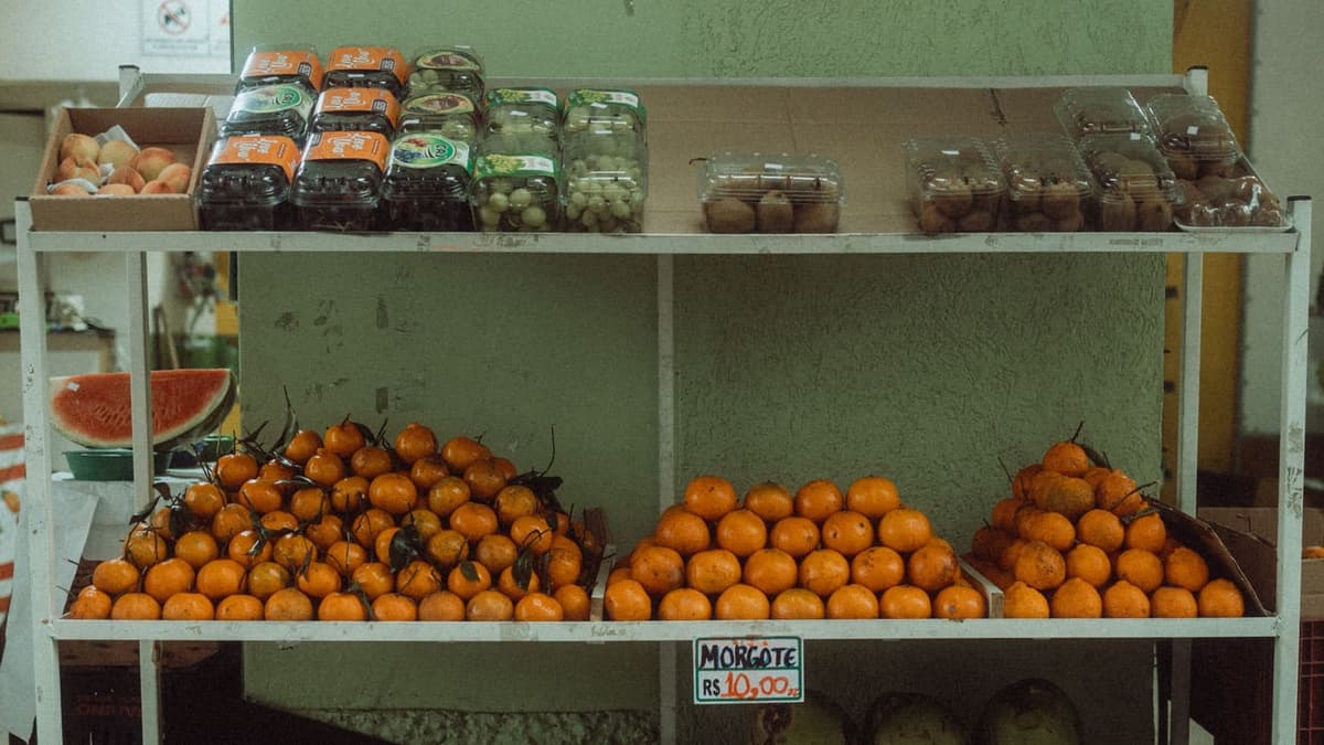 Prateleiras de mercearia com frutas separadas por tipo em cada nível